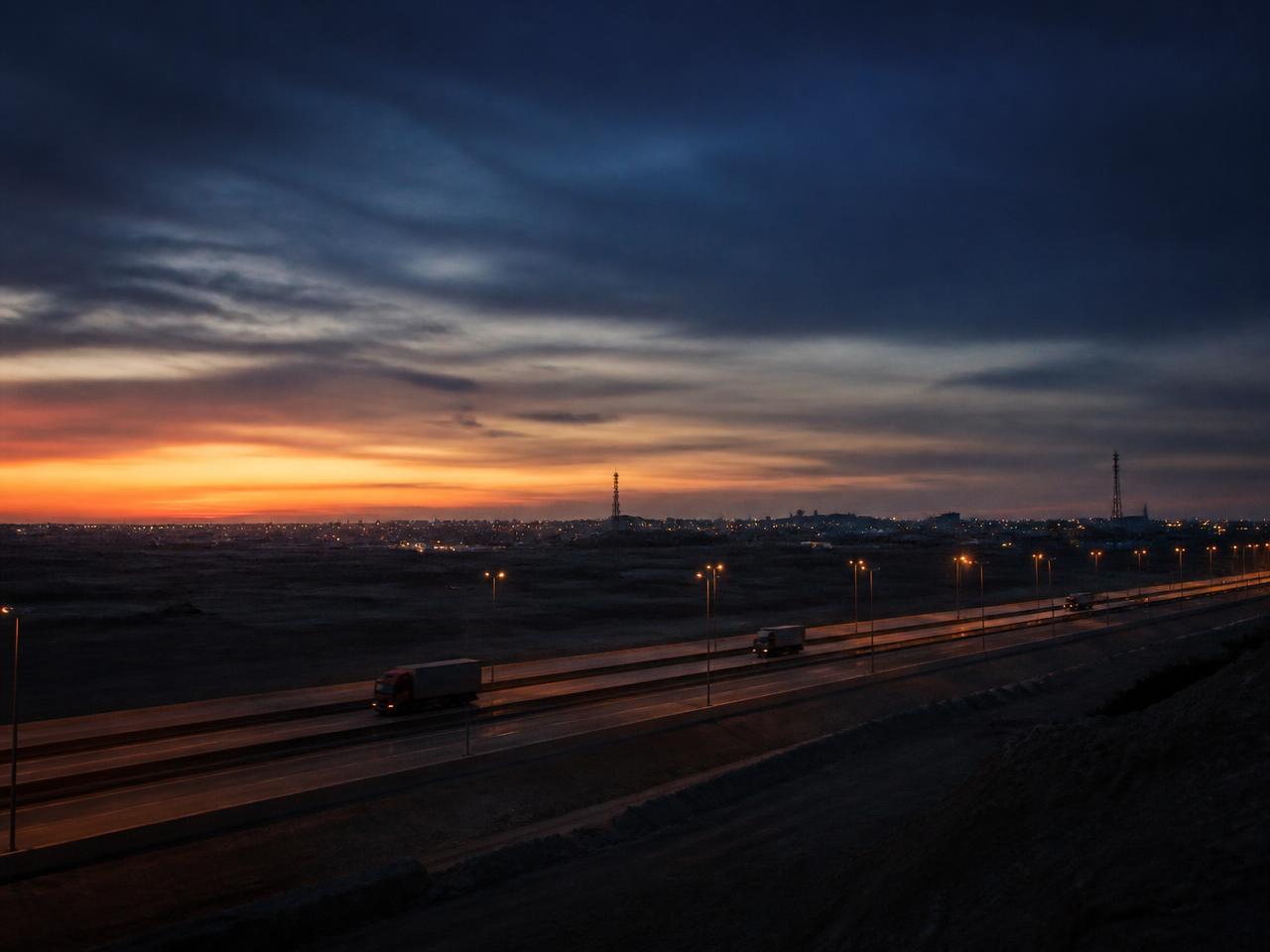 Dawn over an Egyptian logistics corridor with communication towers on the horizon